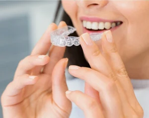 Patient holding a clear Invisalign aligner during a dental consultation