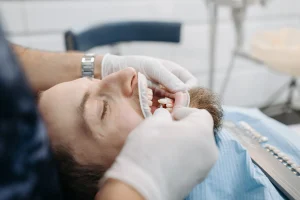 Dentist showing a dental bridge model to a patient with a missing tooth